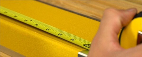 Tape Measure stretched out to align the decking with the bolt down plates.